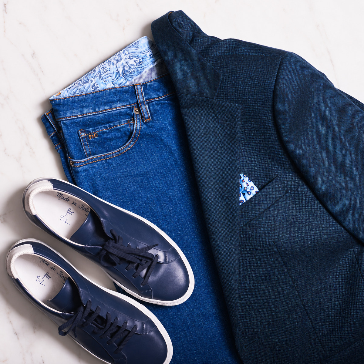 Blue jeans, a navy blazer and coordinating Consiglieri sneakers