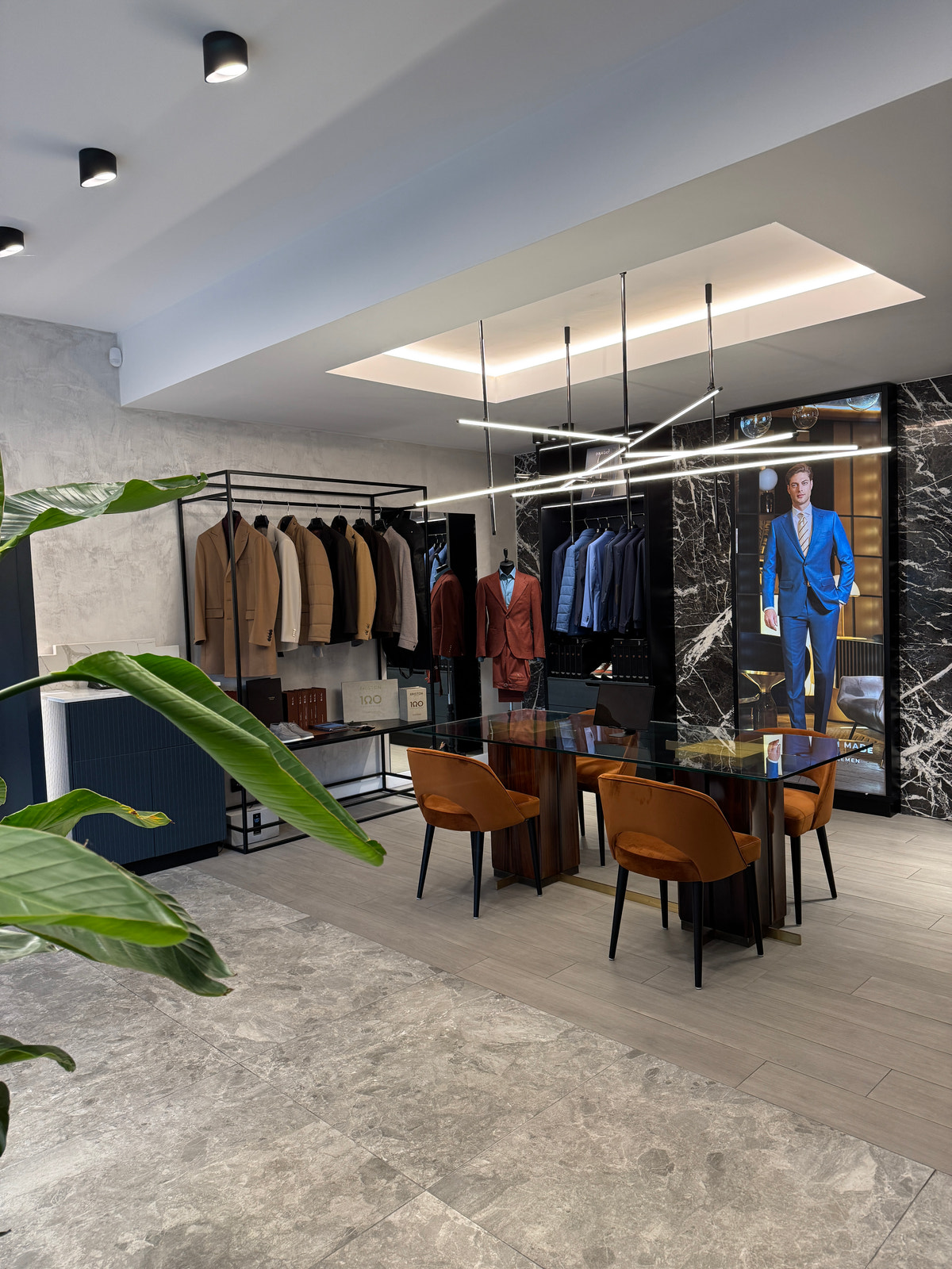 The Consiglieri Cluj-Napoca consultation room, with jacket displays and plants in the foreground.