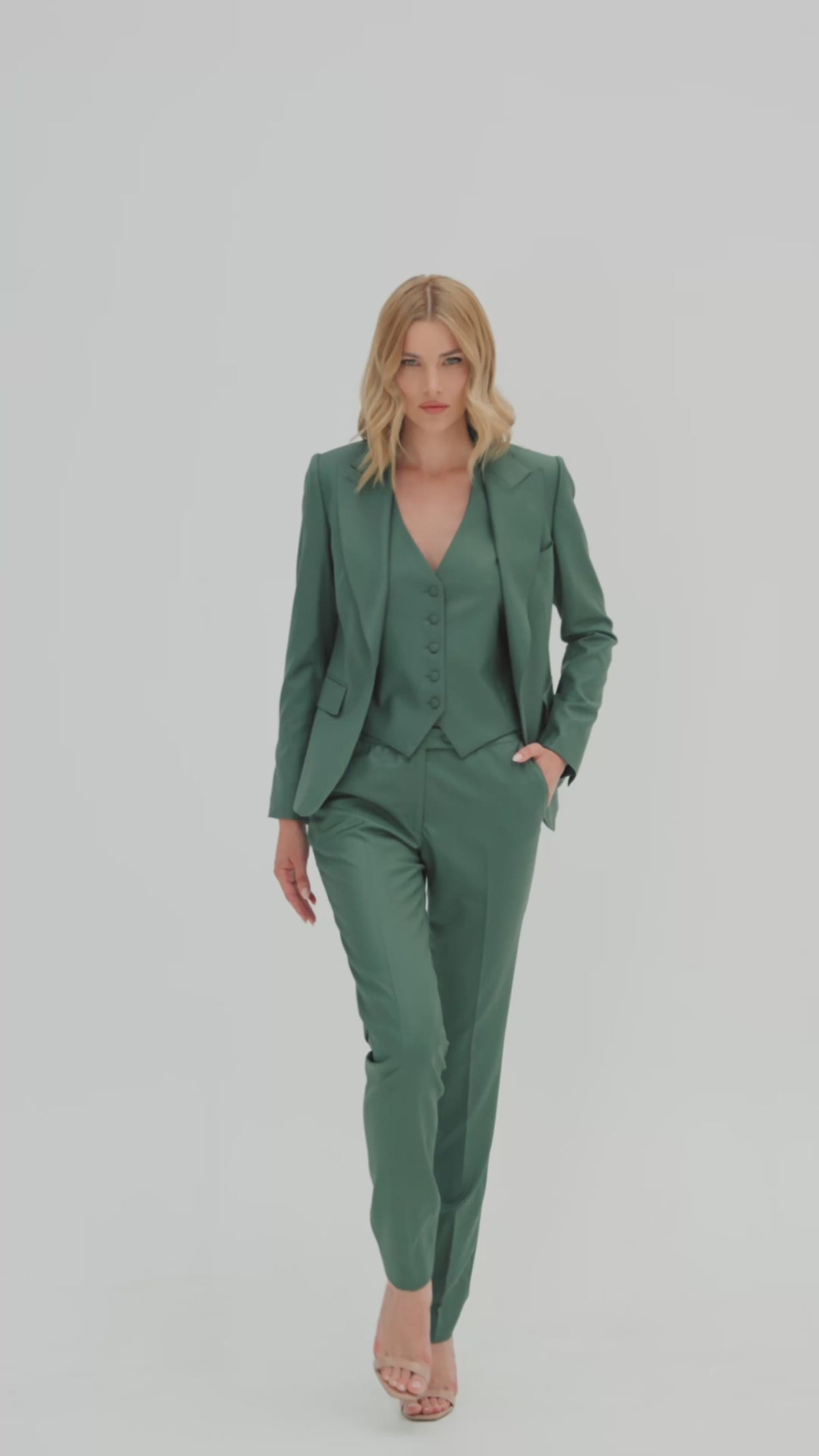 Women’s green three-piece suit with a waistcoat and fitted jacket