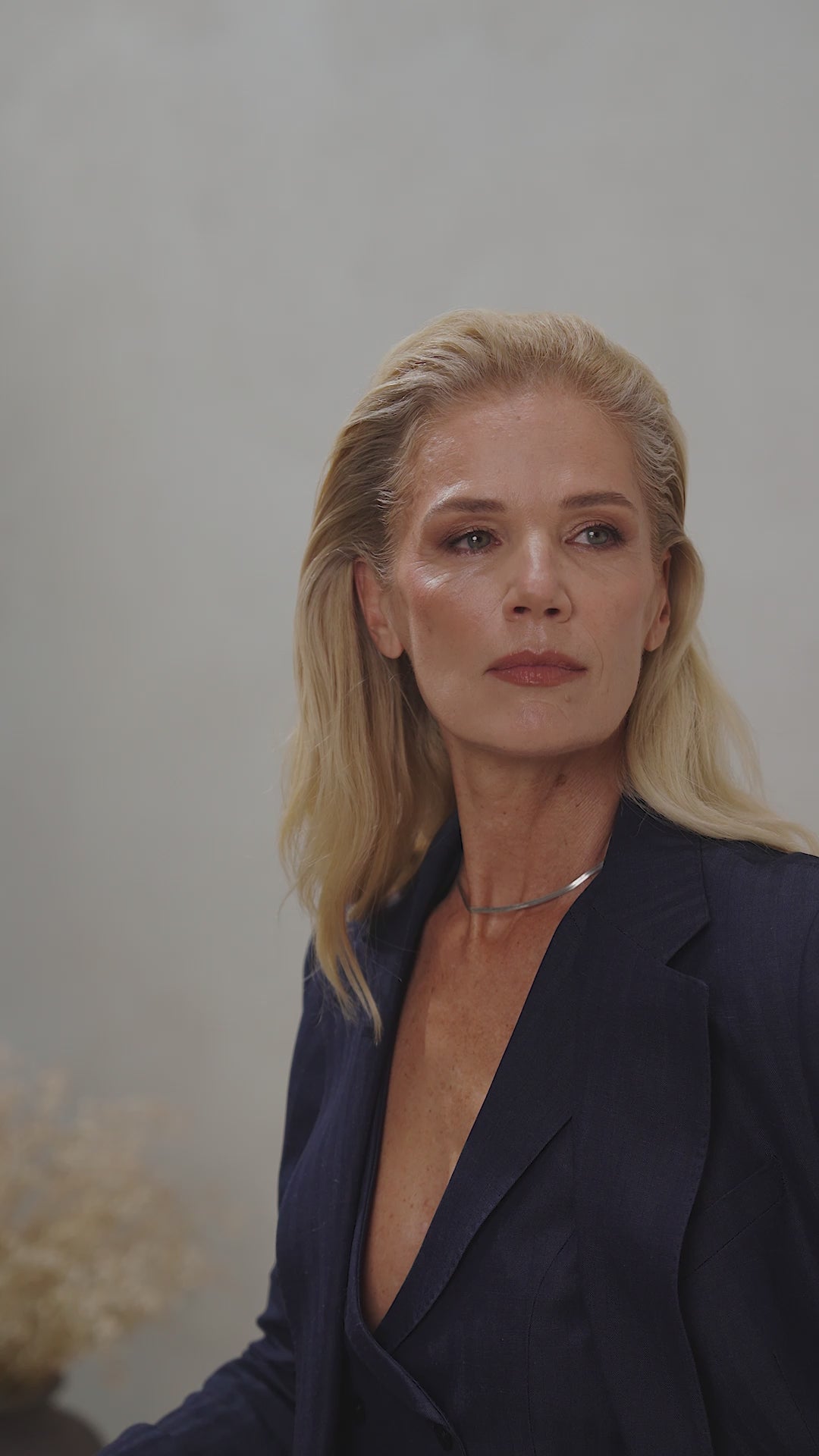 A woman in a navy Consiglieri The Signature Suit blazer with wide lapels