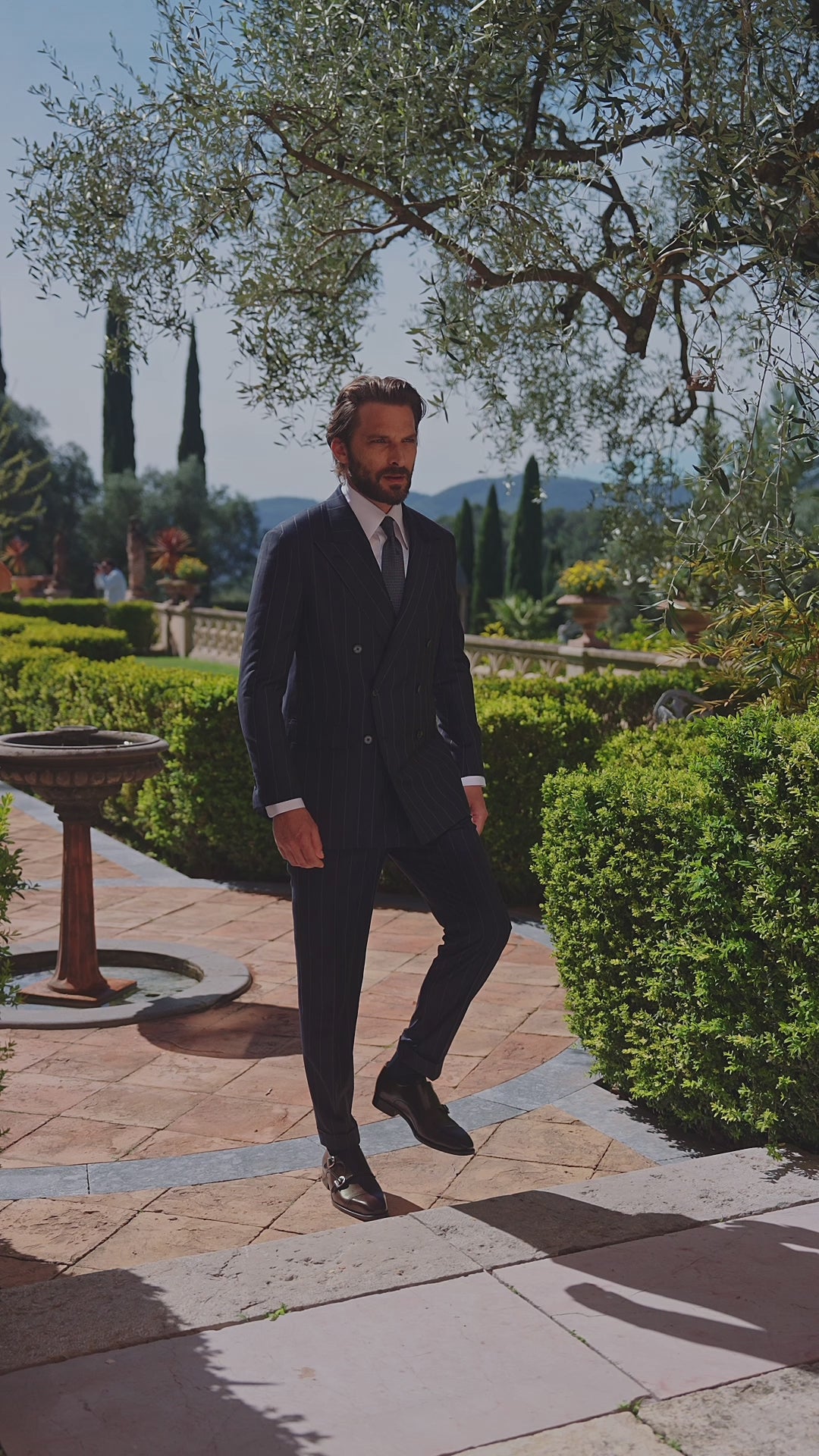 Men’s dark suit worn on a garden path