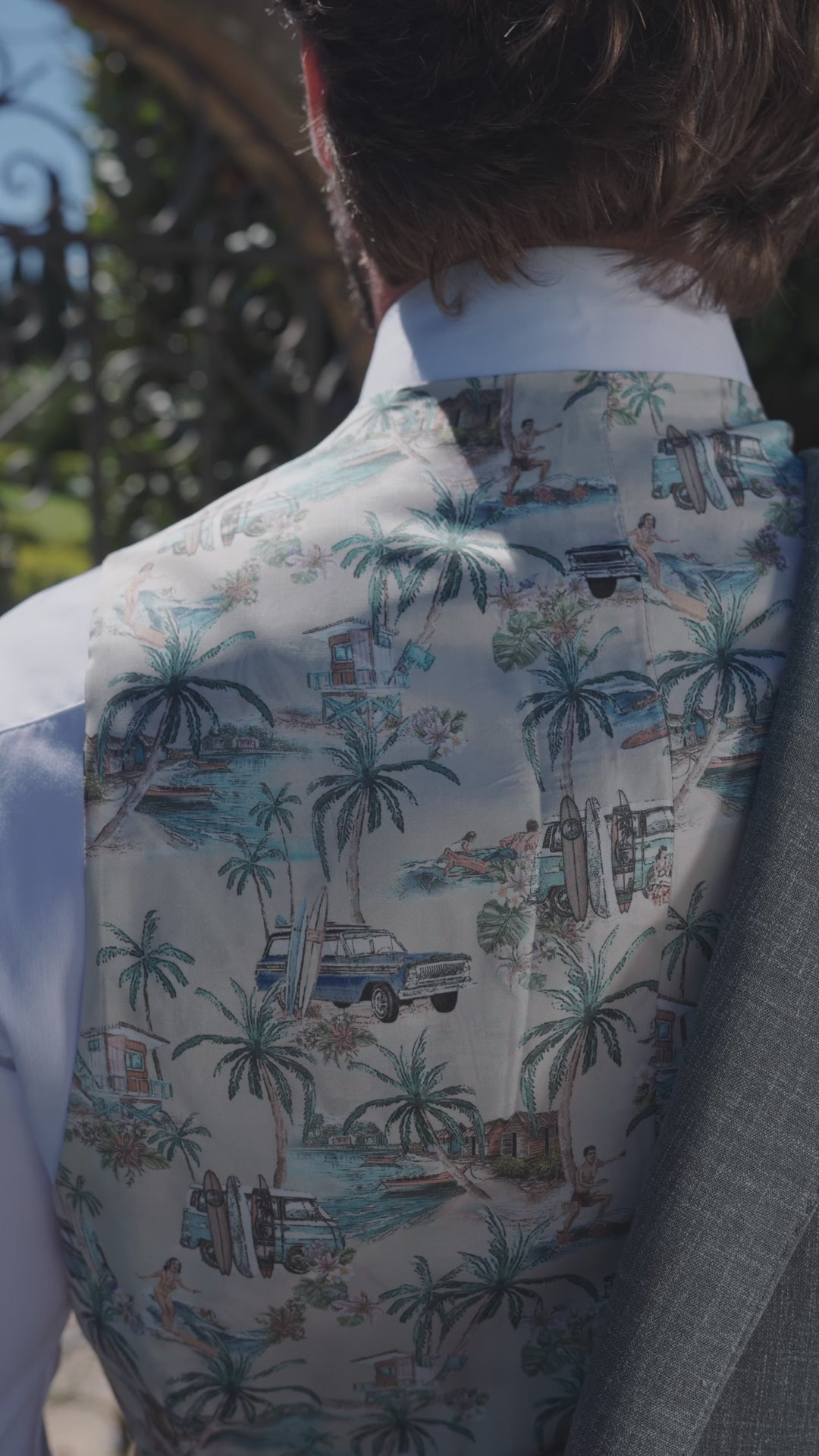 The back of a Consiglieri waistcoat patterned with palm trees and summer scenes