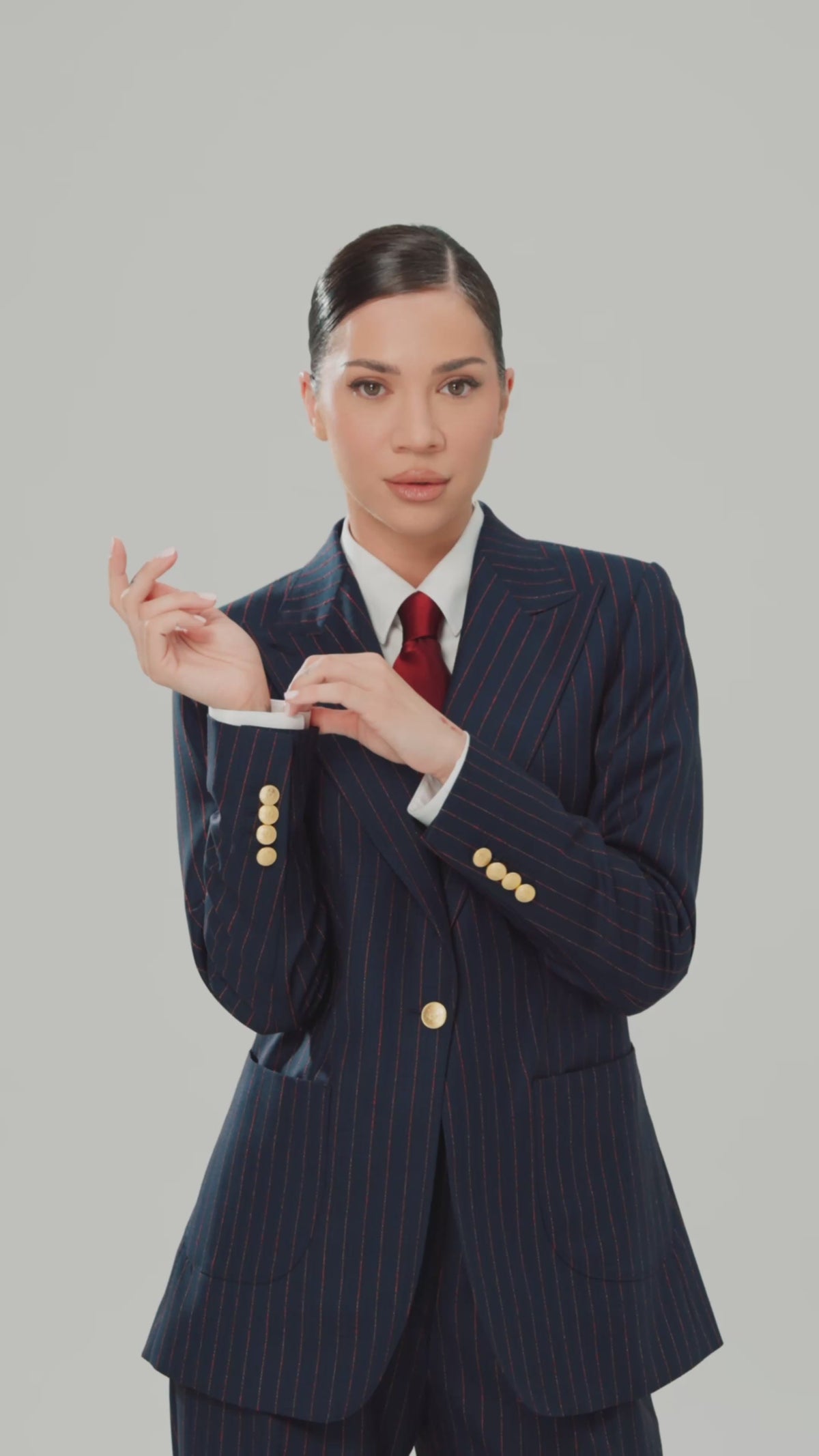 Women’s navy striped jacket with gold buttons and a burgundy tie
