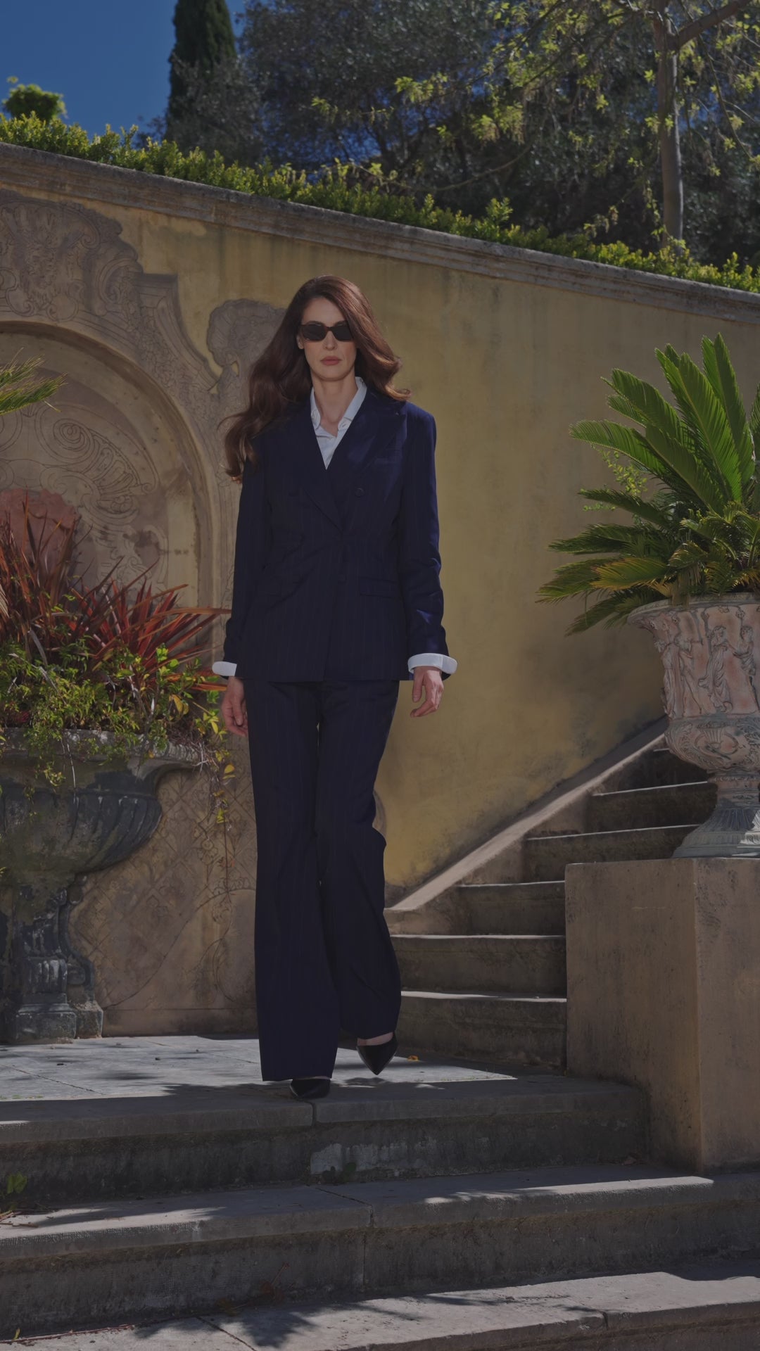 Navy Consiglieri Sorrento women's suit with a white shirt on stone steps