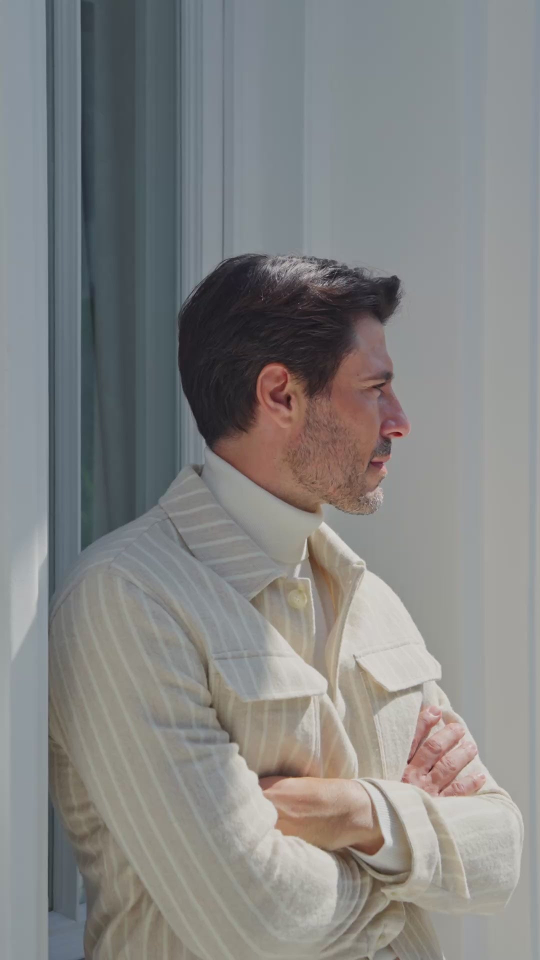 Beige jacket with chest pockets over an ivory roll-neck sweater