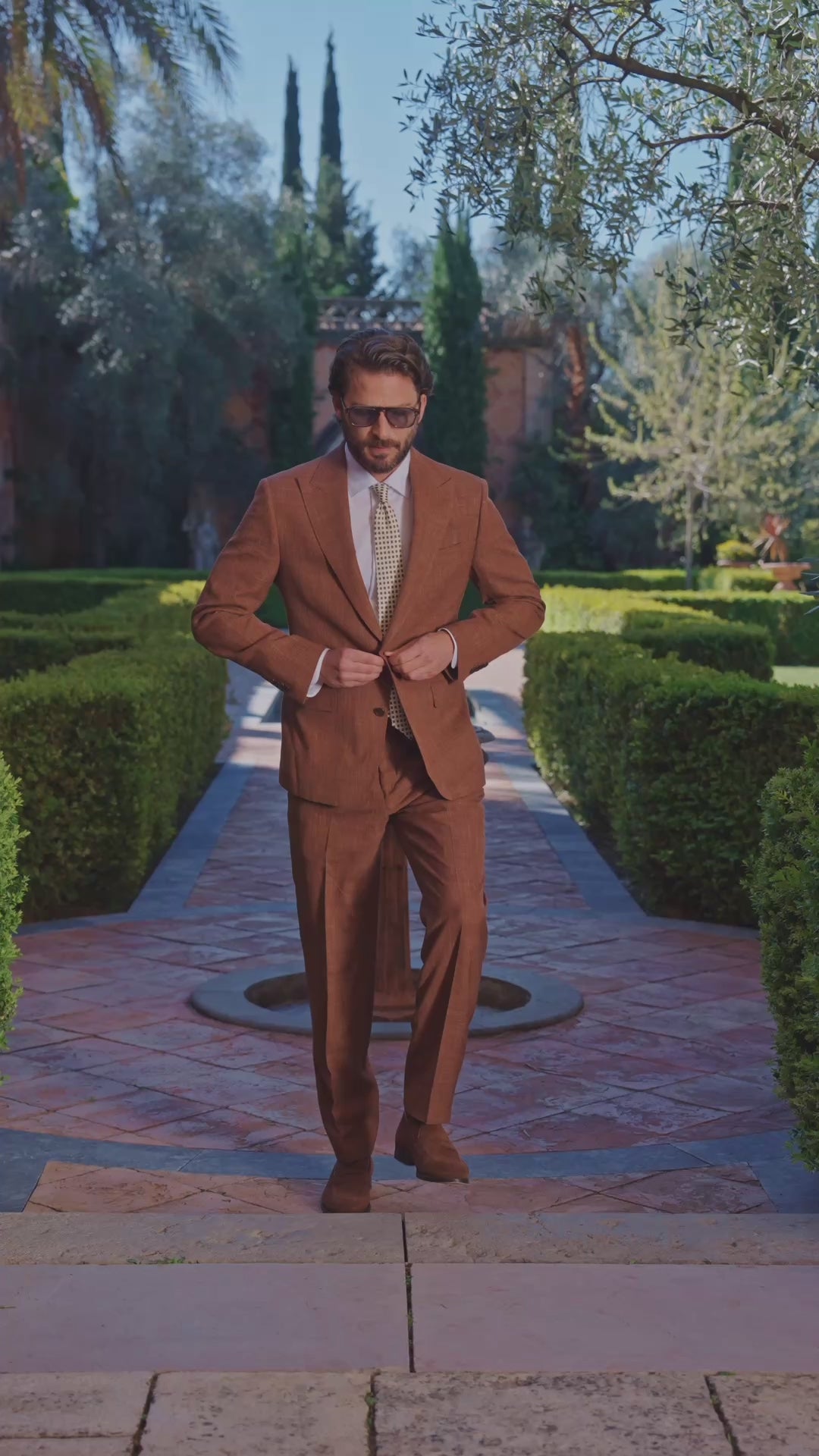 Copper Consiglieri Terre d’Azur suit with a pale shirt in a garden