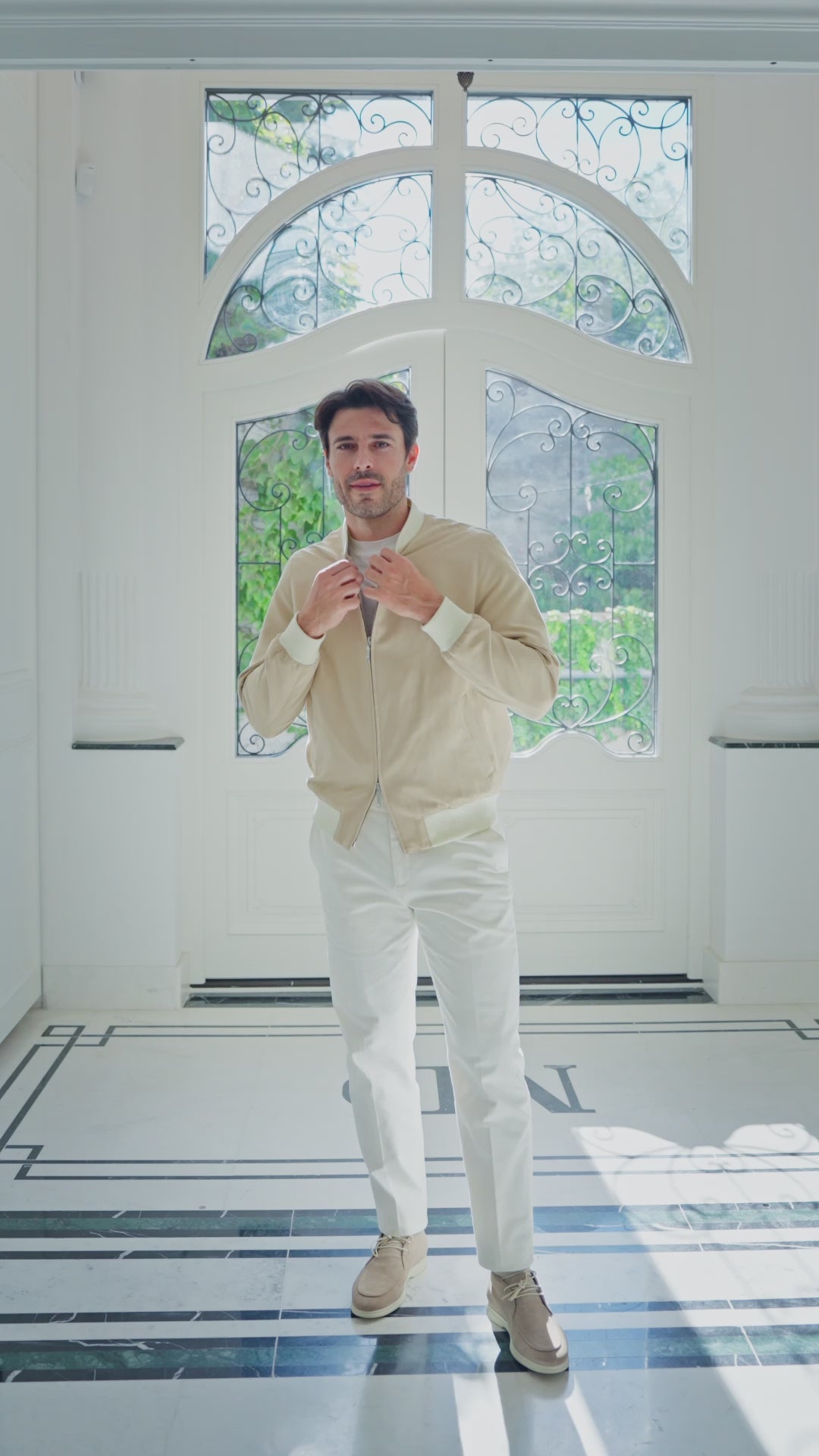 Cream jacket and white trousers in an interior with ornate doors