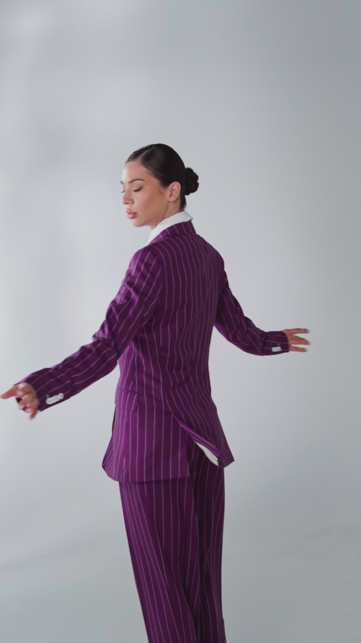 Women’s violet pinstripe suit captured in motion