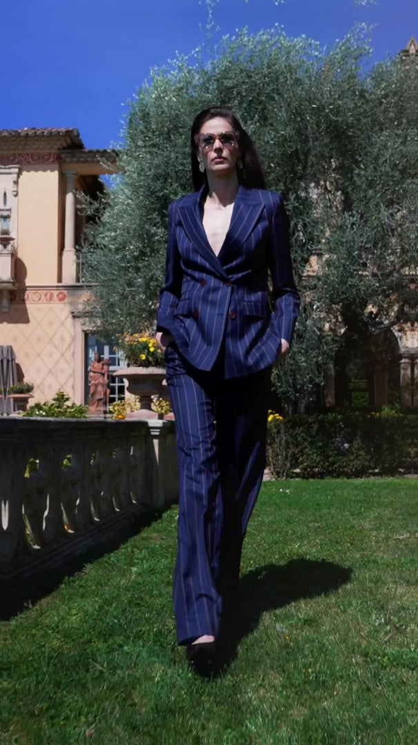 Women’s navy suit worn with sunglasses in a sunlit garden