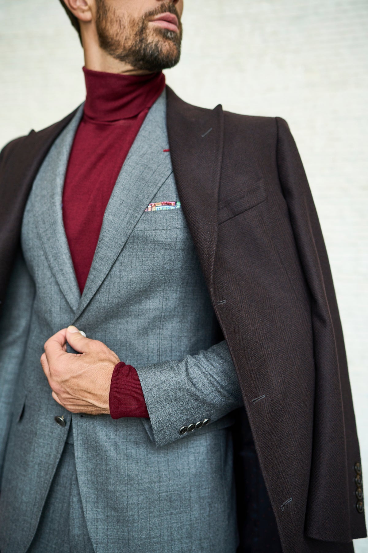 Consiglieri Meribel: dark overcoat lapel beside a grey jacket and burgundy roll-neck