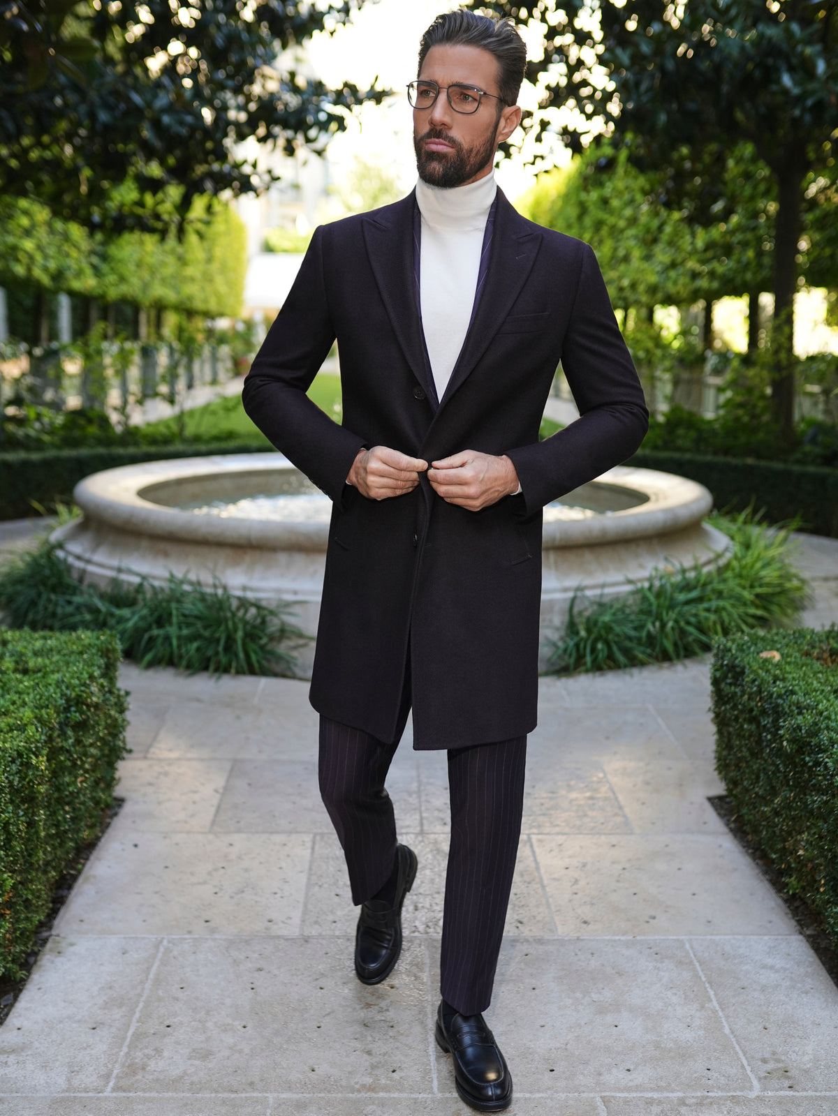 Consiglieri St Moritz: dark overcoat with a white roll-neck and tonal trousers