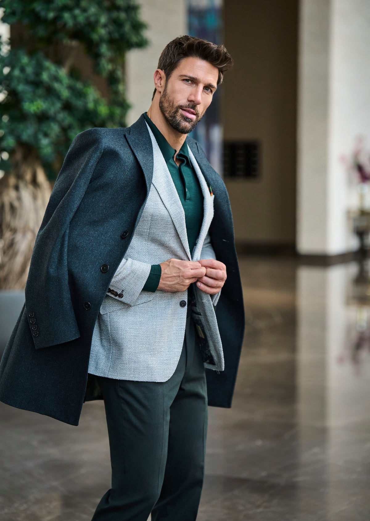 Consiglieri Val d'Isere: dark green overcoat draped over a light grey jacket