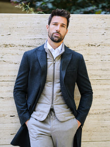 Consiglieri: ivory quilted gilet beneath a dark overcoat