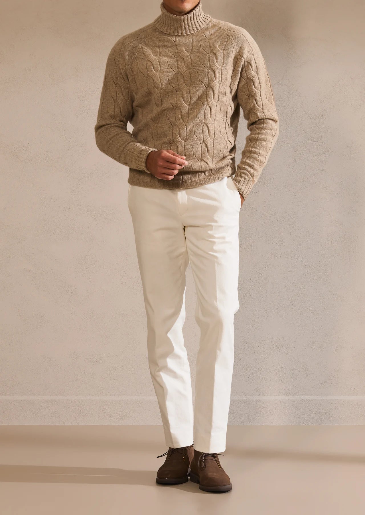 Beige cable turtleneck with light trousers and brown shoes