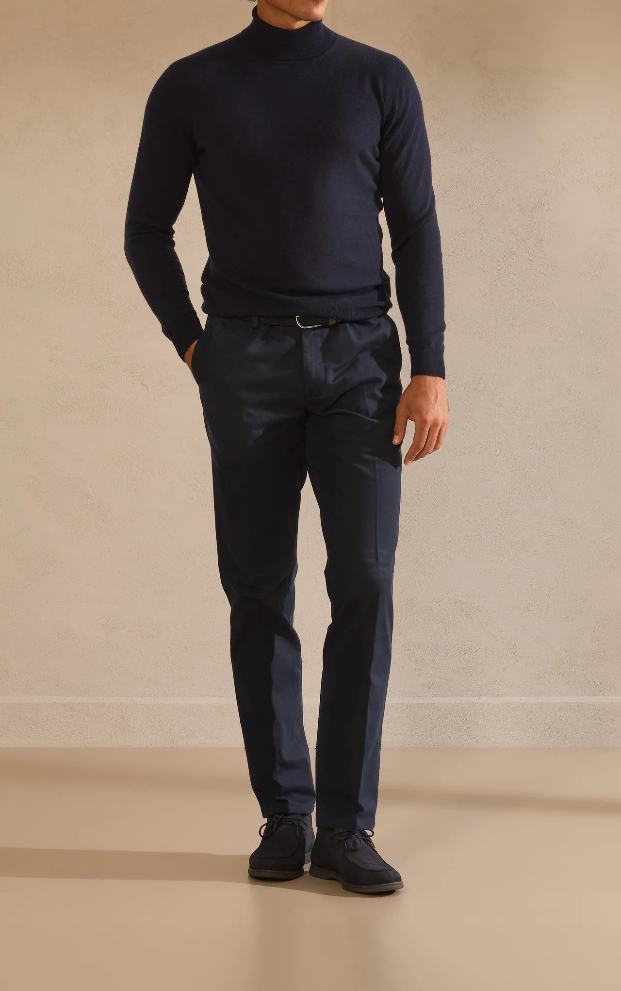 Navy high-neck knit with trousers and footwear in matching dark tones.
