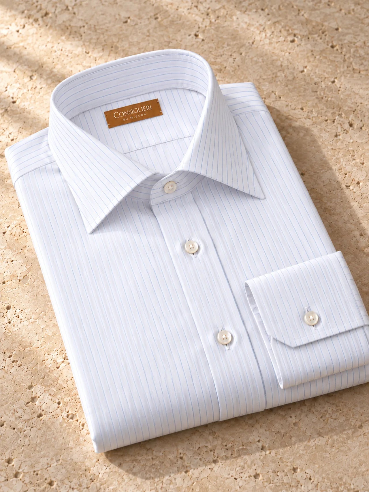 Folded fine blue stripe shirt, with the collar and cuff in view.