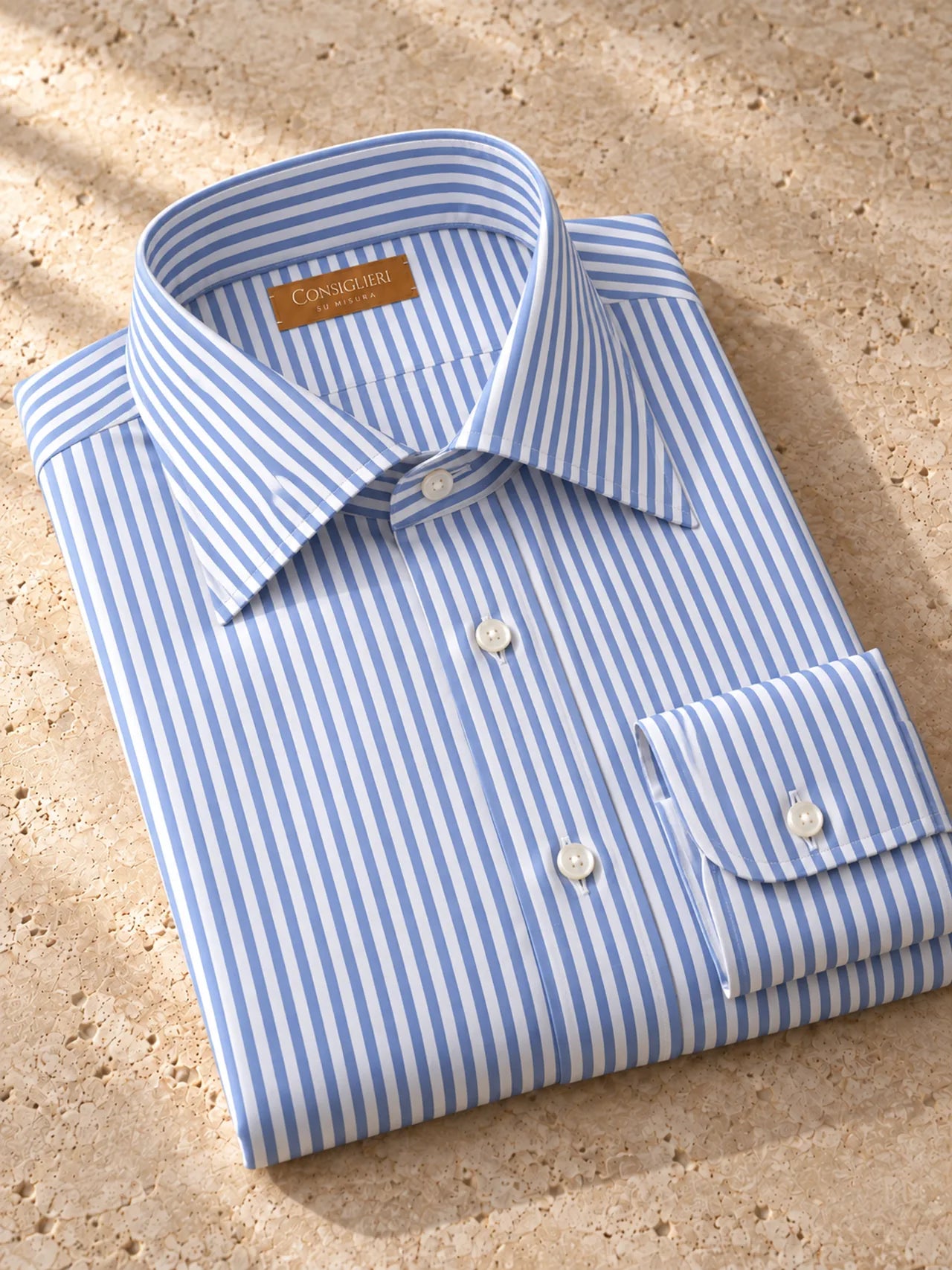 Folded blue stripe shirt, with the collar and cuff in view.