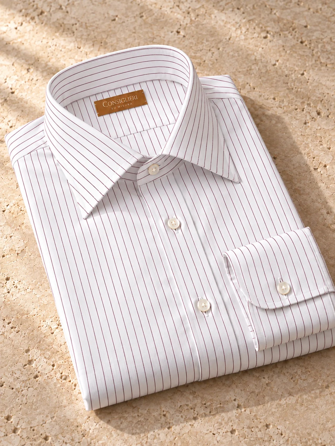 Folded burgundy accent shirt, with the collar and cuff in view.