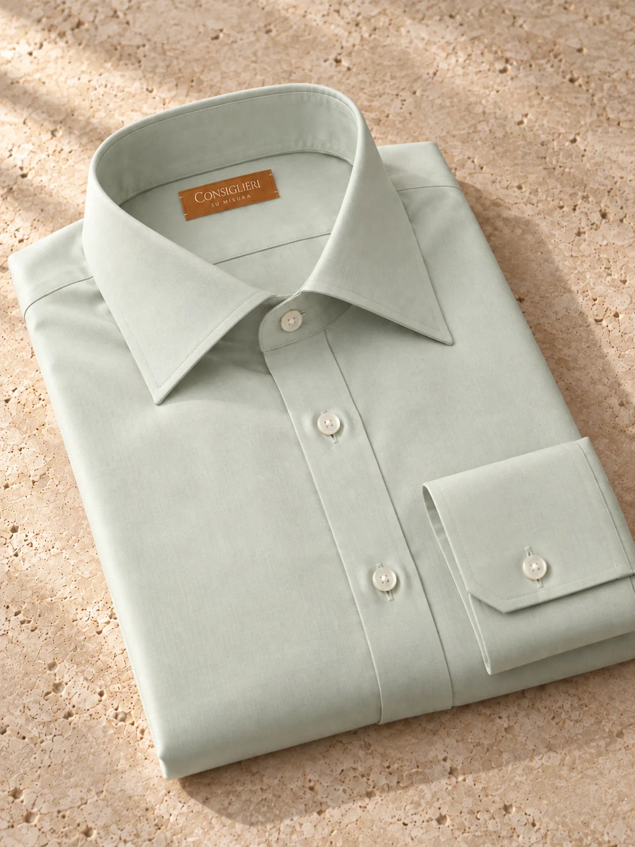 Folded quiet sage shirt, with the collar and cuff in view.